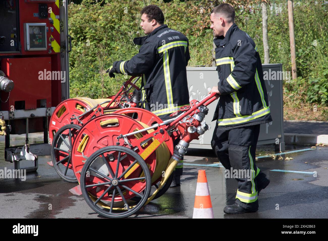 Val D'Oise France. Firefighters damping down potential dry grass hotspot Stock Photo