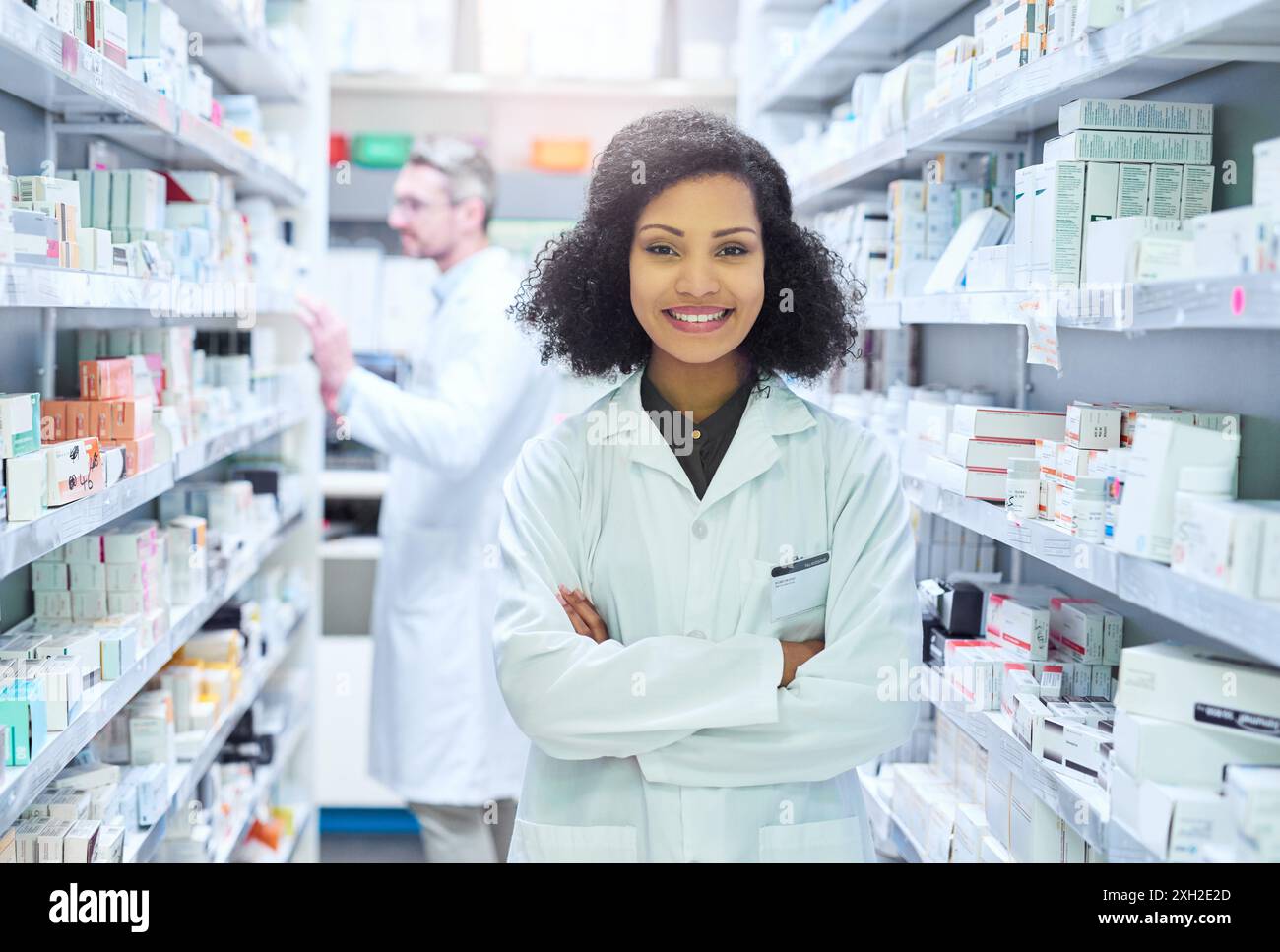 Healthcare, confidence and portrait of woman in pharmacy with smile, advice and about us in drug store. Happy, arms crossed and pharmacist with Stock Photo