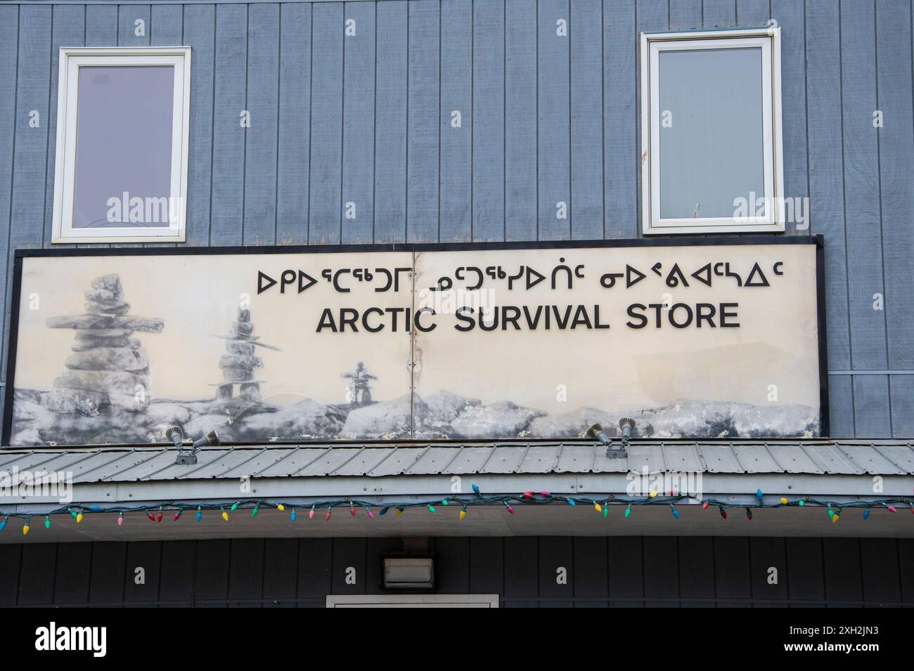 Bilingual Arctic Survival Store sign in English and Inuktitut on Nipisa Street in Iqaluit, Nunavut, Canada Stock Photo