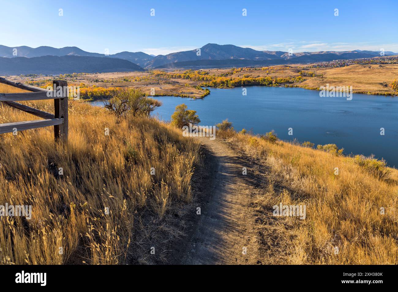 Autumn Mountain Trail - Autumn day view of a winding biking/hiking trail, overlooking Bear Creek Lake Park, at side of Mt. Carbon. Lakewood, CO, USA. Stock Photo