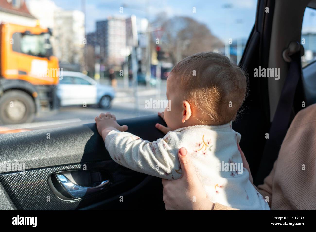 A child plays in a car and looks out the window with interest. Concept ...