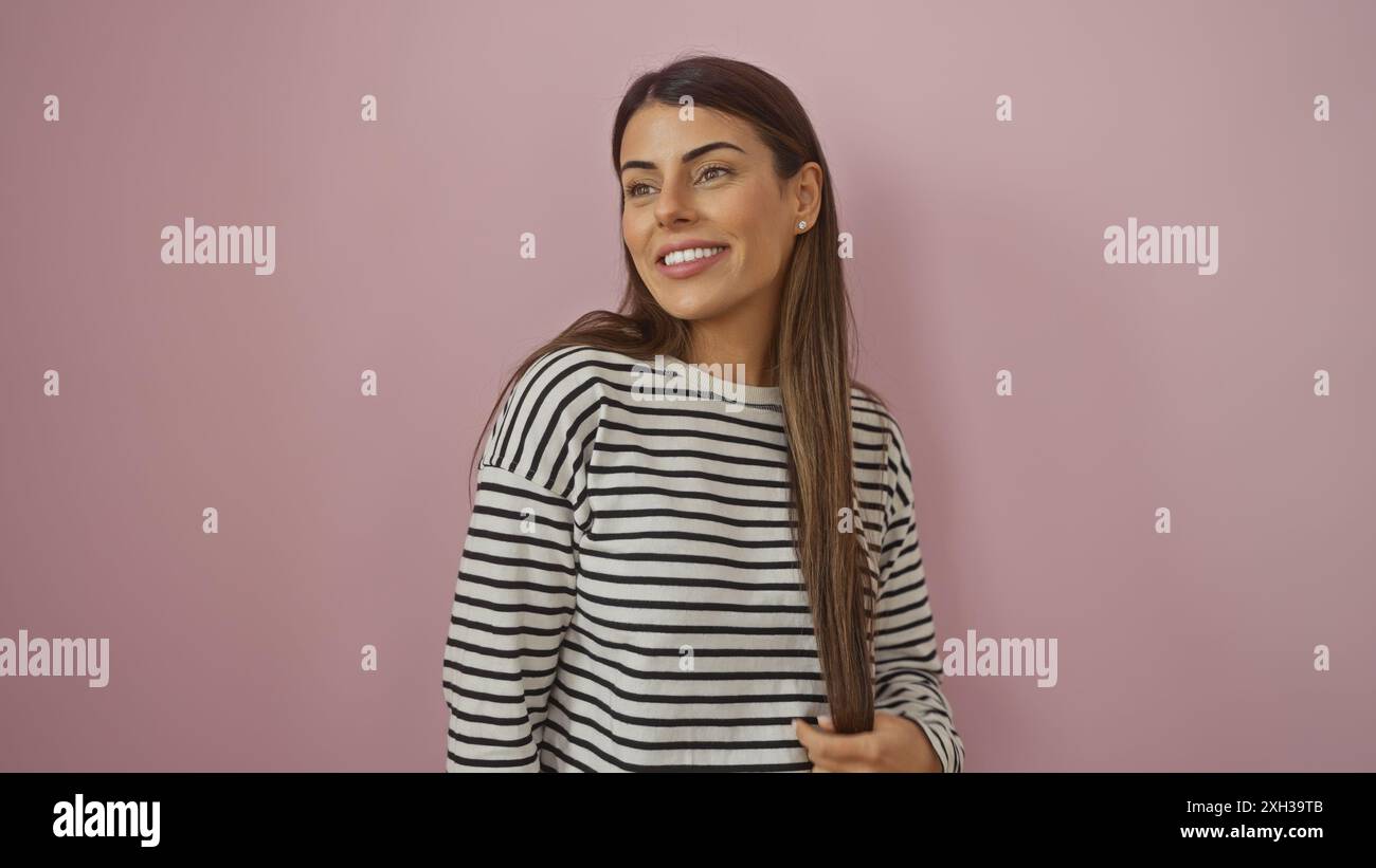 Hispanic Poses A smiling young hispanic woman in a striped shirt poses against a plain ...