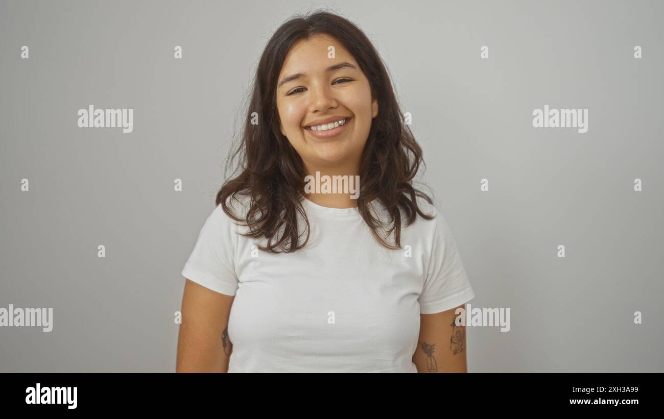 Hispanic Poses A young beautiful hispanic brunette woman smiles confidently while ...