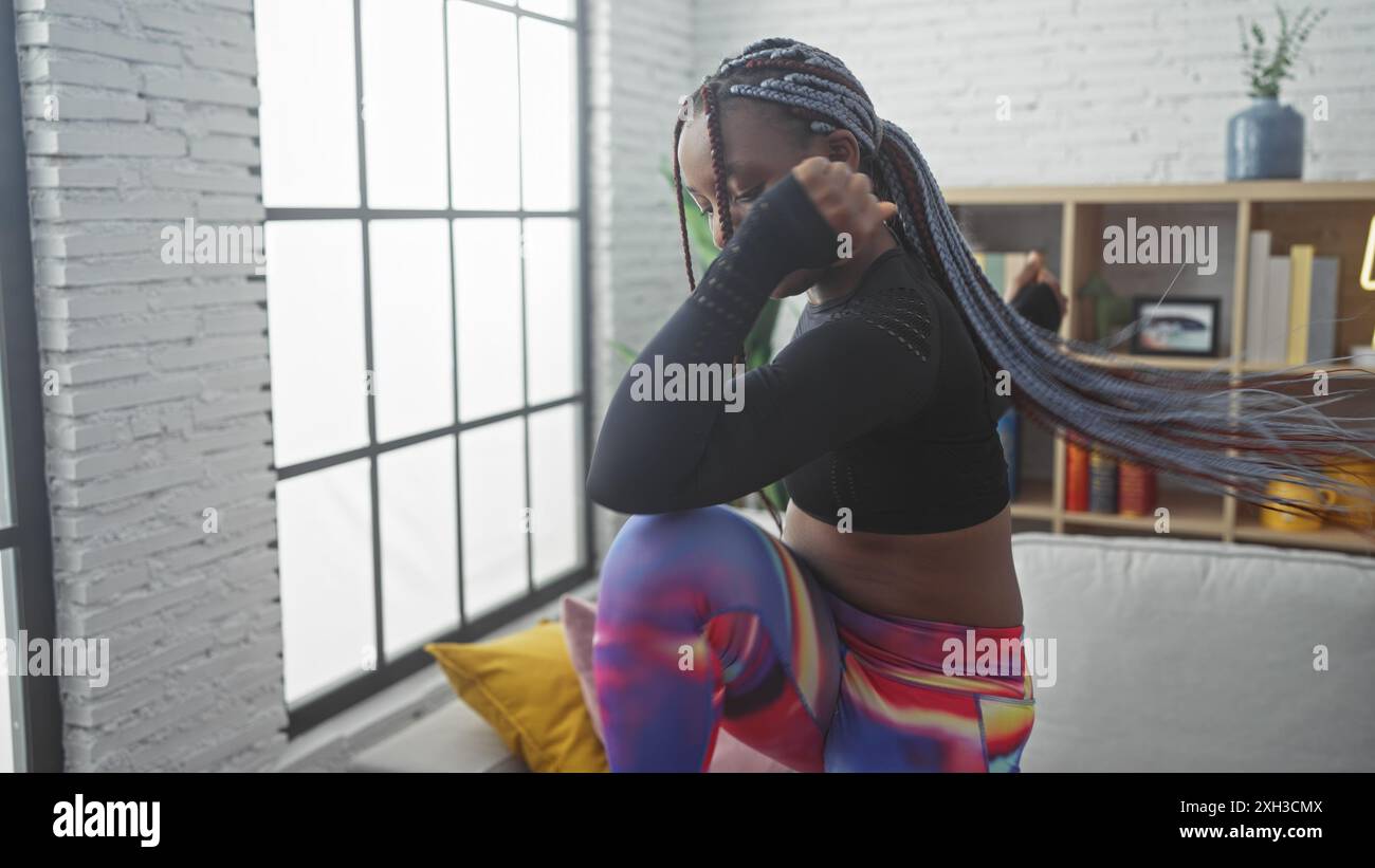 African american woman with braids in activewear posing indoors against ...