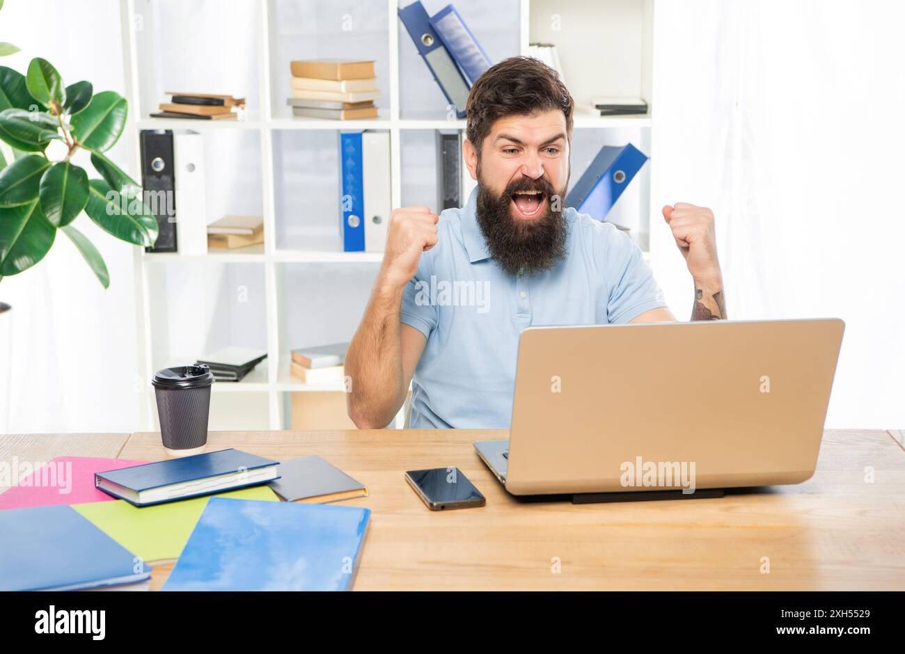 Excited businessman celebrating victory looking in laptop at office ...