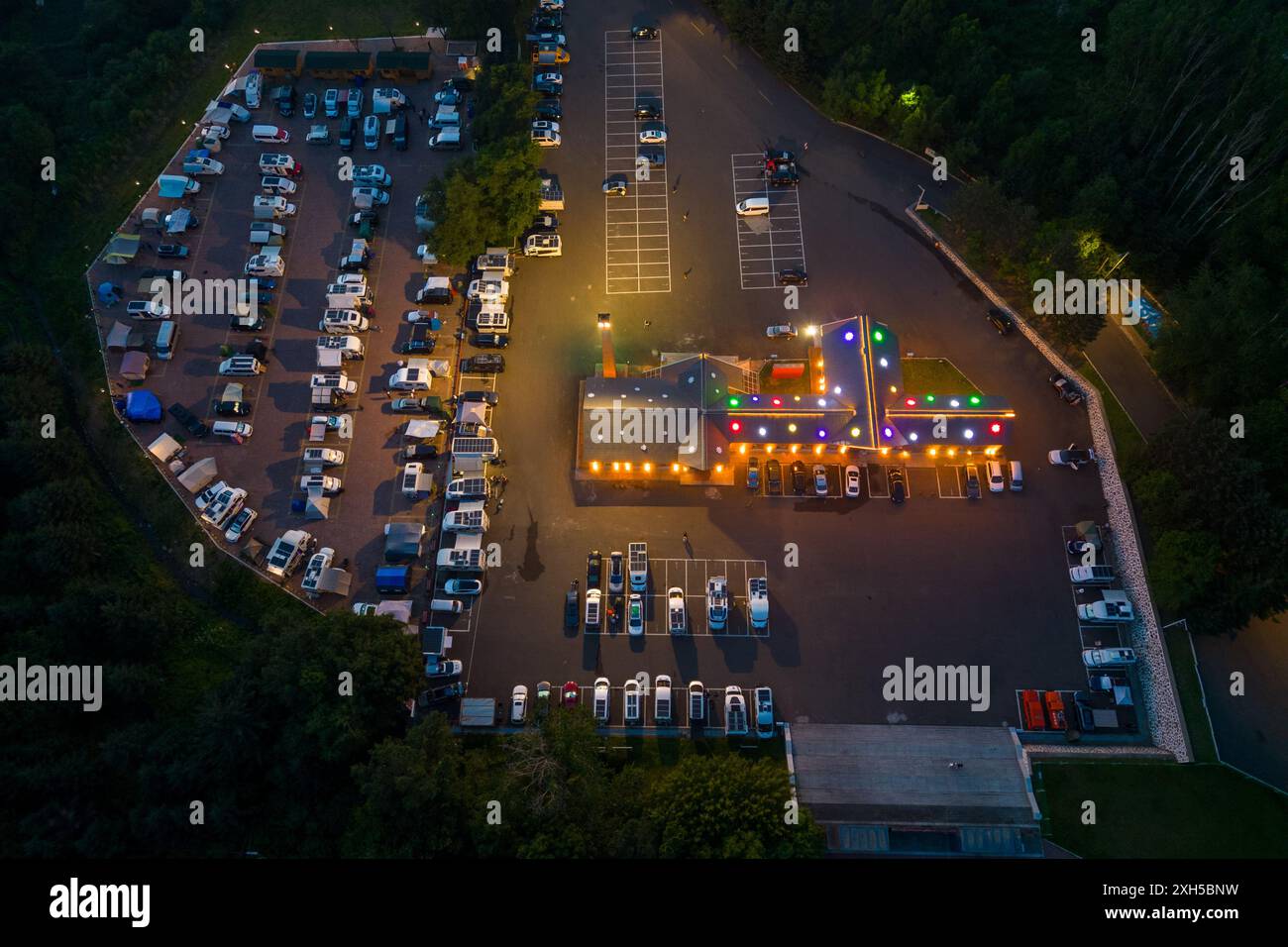 Yichun. 11th July, 2024. This aerial drone photo taken on July 11, 2024 shows vehicles parking at a RV camp in Xing'an National Forest Park in Yichun, northeast China's Heilongjiang Province. Yichun in northeast China's Heilongjiang Province becomes a popular travel destination in summer. With the city's abundant forest resources, many tourists come here for its fresh air and mild temperature. Credit: Zhang Tao/Xinhua/Alamy Live News Stock Photo