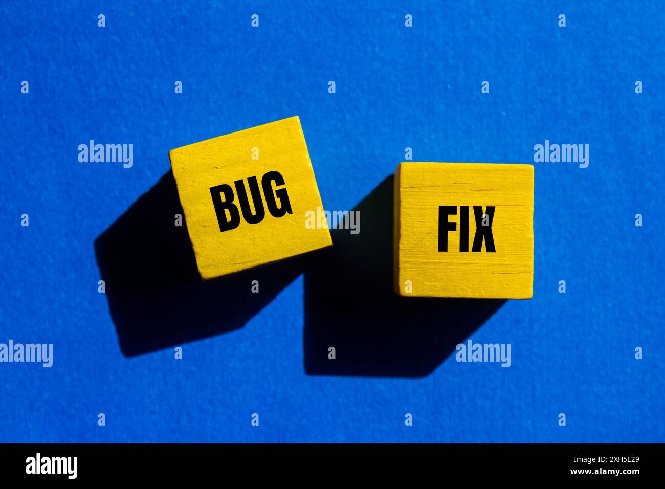 Bug fix message written on yellow wooden cubes with blue background ...