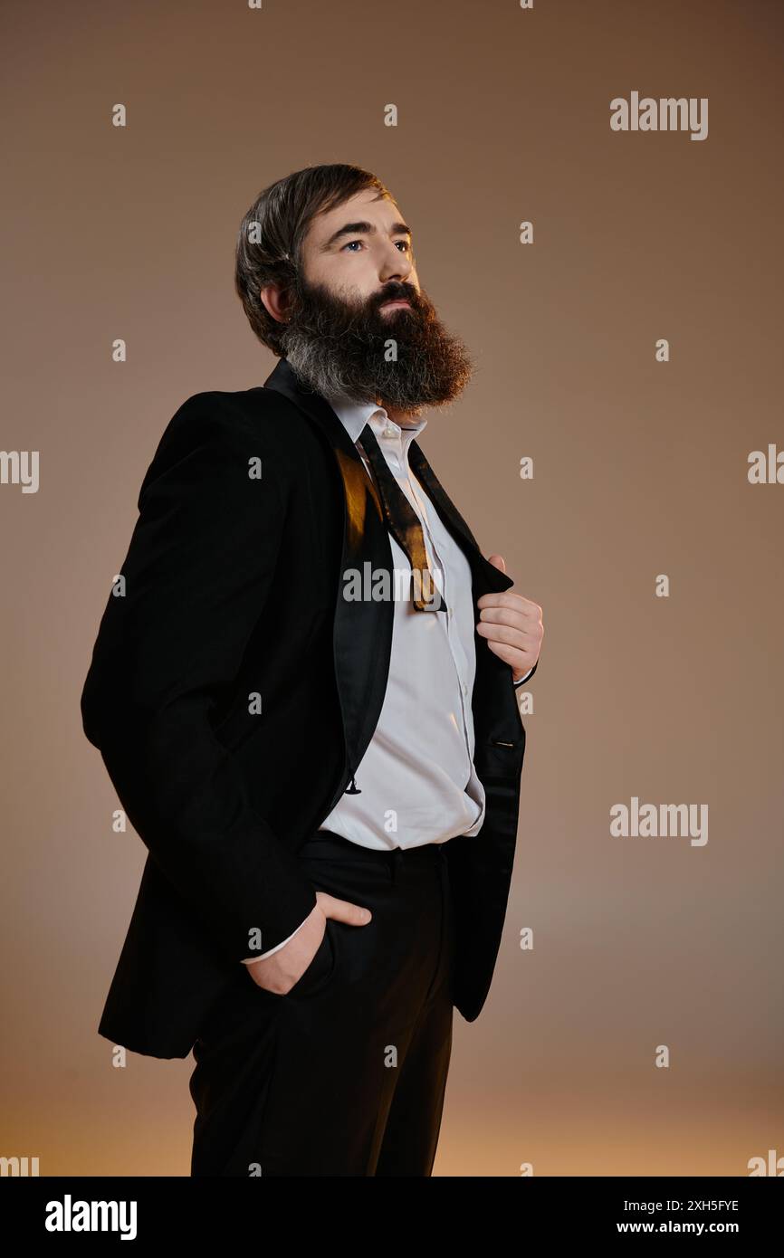 A man in a black suit, white shirt, and a bold tie poses against a ...