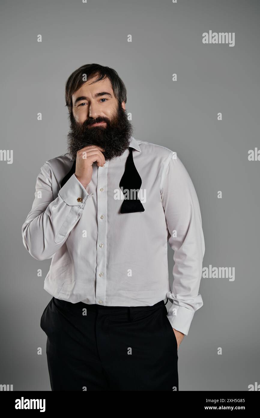 A man in a white shirt and black bow tie poses confidently against a ...