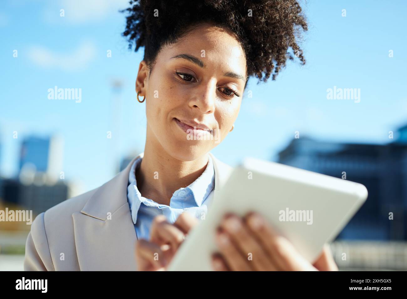 Confident Young Businesswoman Using Tablet in Urban Setting Stock Photo