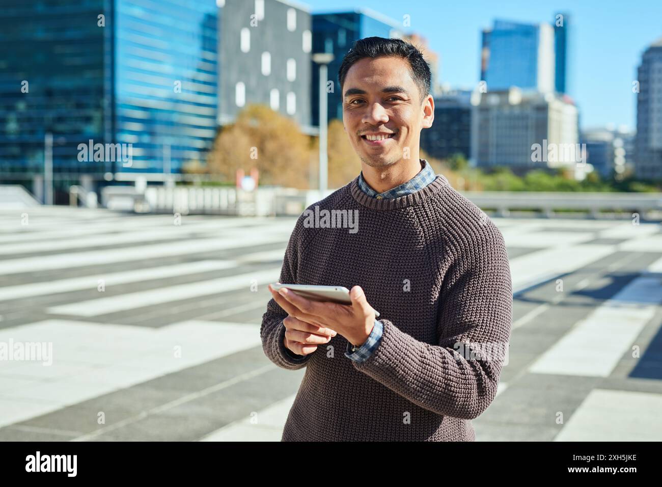 Confident Entrepreneur Using Mobile Device in Modern Urban Environment Stock Photo