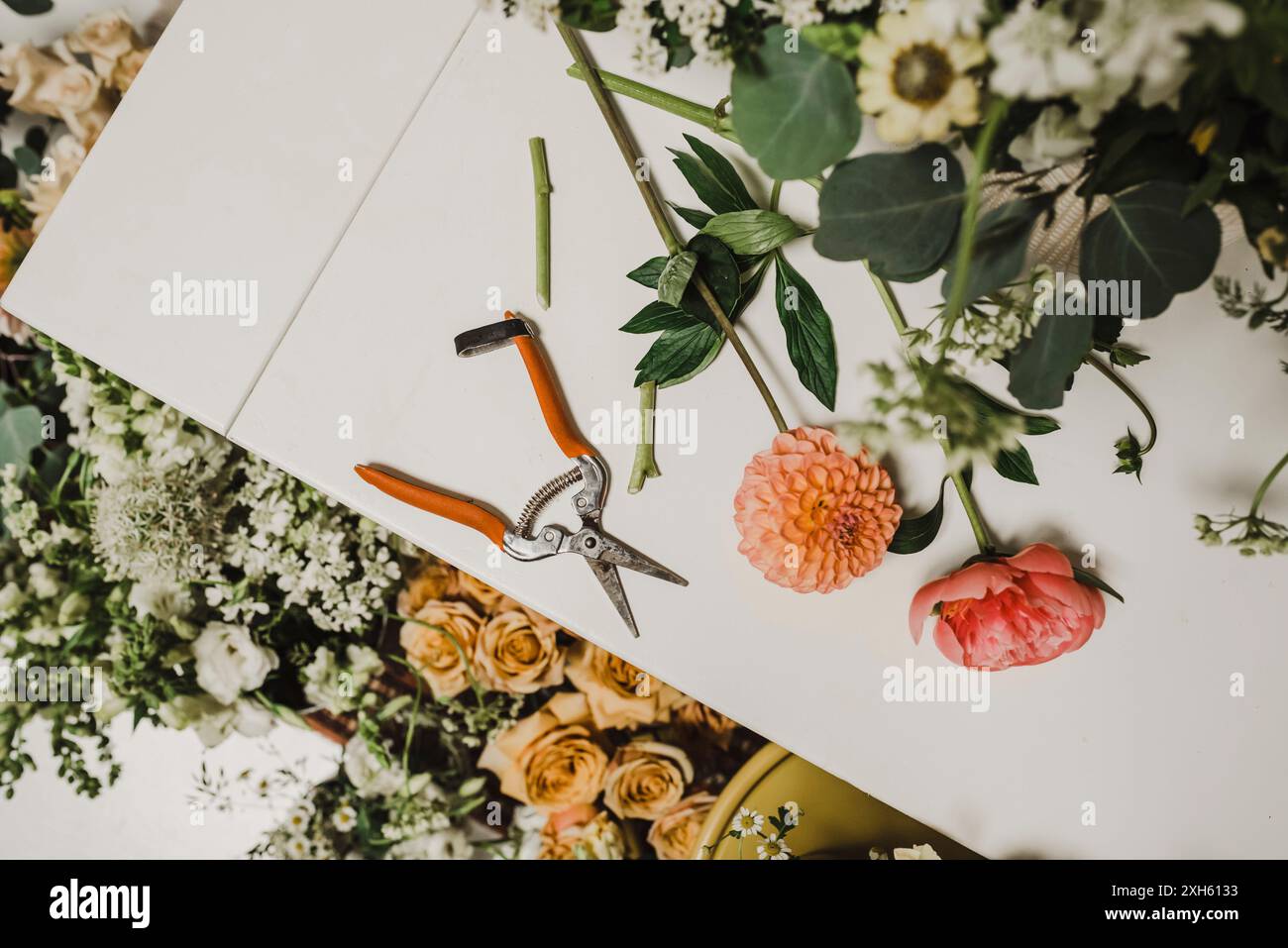 Floral arrangement tools and flowers on a white table Stock Photo - Alamy