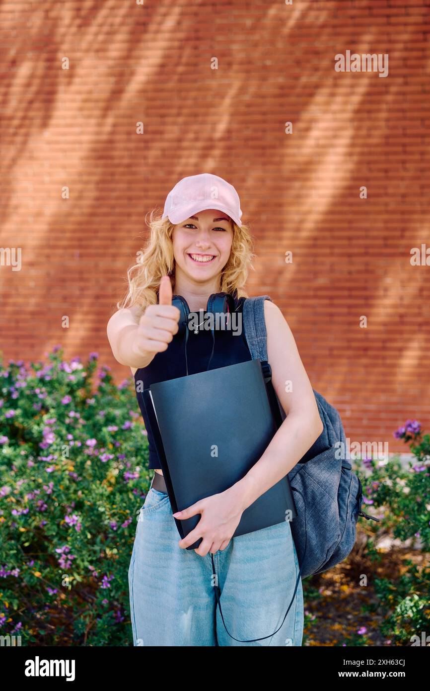 Student giving thumbs up on campus Stock Photo - Alamy