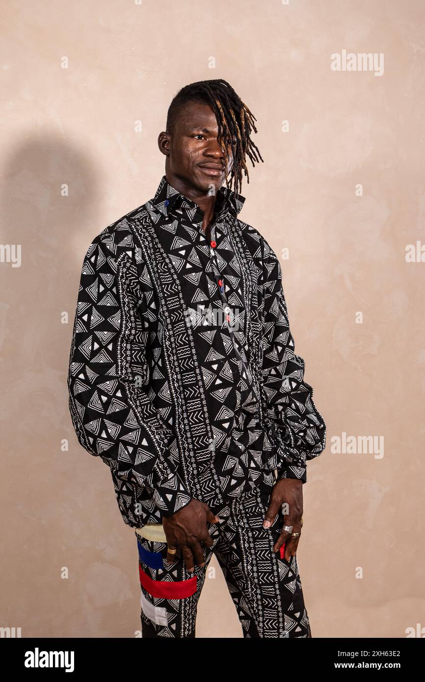Young adult black man posing in a photo studio wearing traditional african clothing Stock Photo