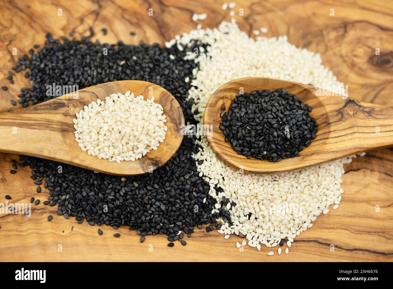 sesamum, sesame (Sesamum indicum), peeled and unpeeled sesame seeds with wooden spoons Stock Photo