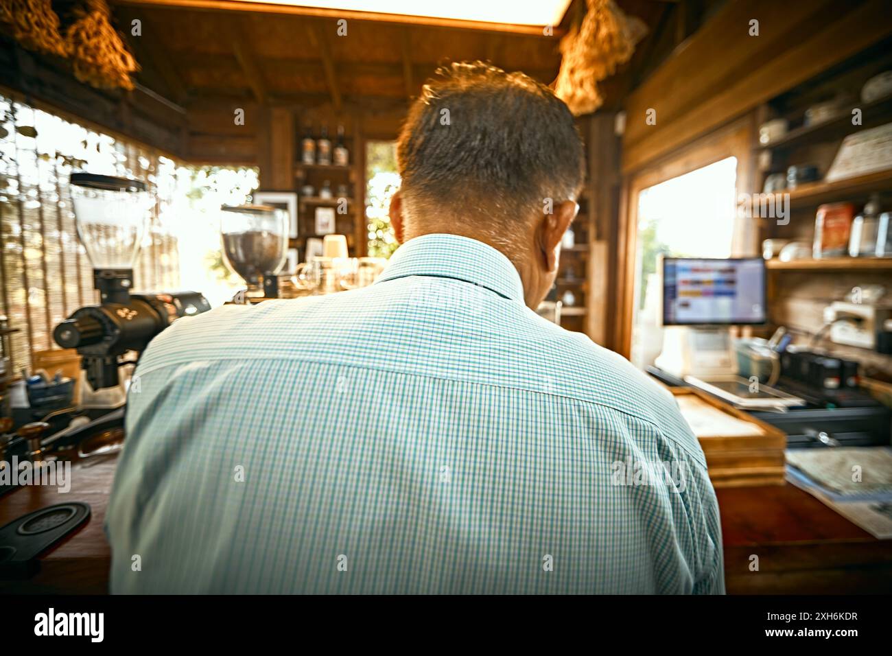 barista preparing coffee in the coffee machine. View from the back. Stock Photo
