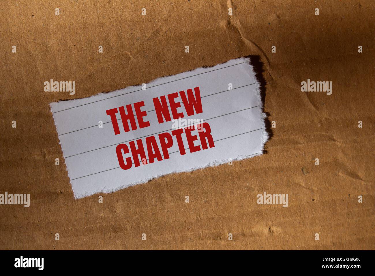 The new chapter message written on ripped torn white paper piece with ...