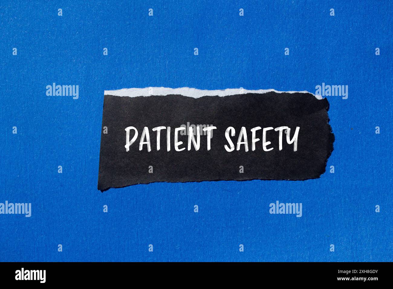 Patient safety message written on ripped torn black paper piece with ...