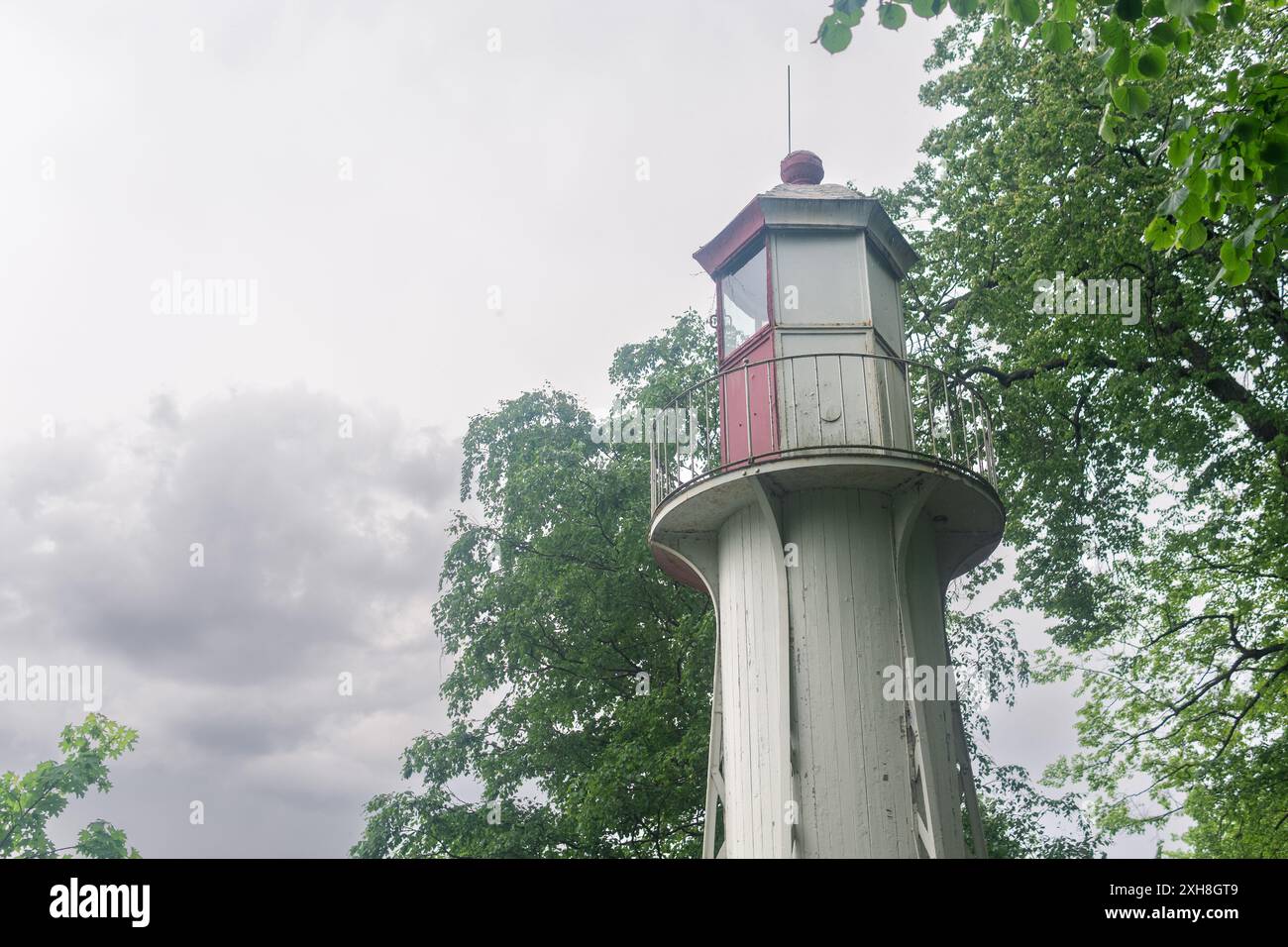 lantern room of an old lighthouse on the seashore among the trees Stock Photo