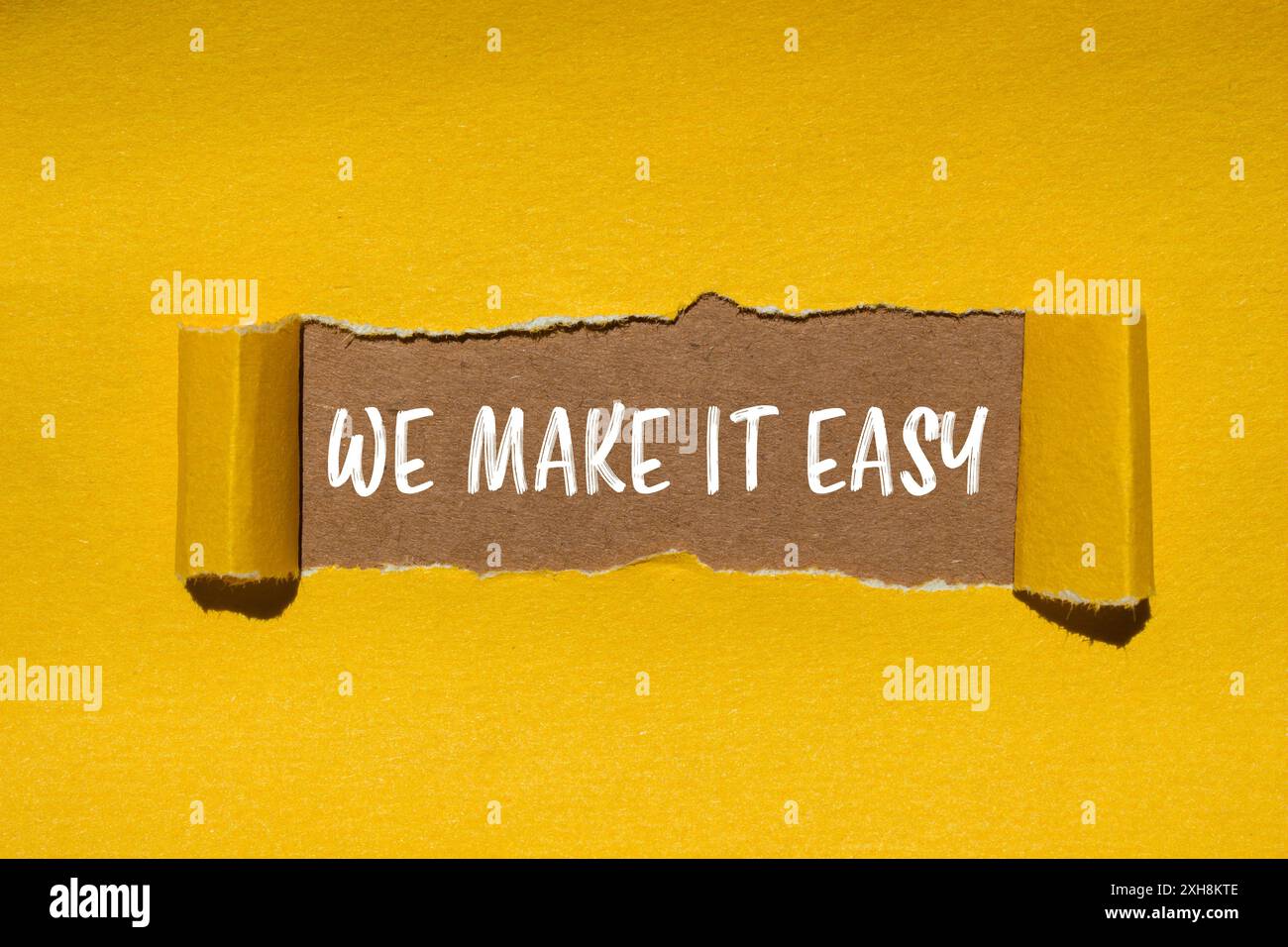 We make it easy message written on ripped torn yellow paper with brown ...