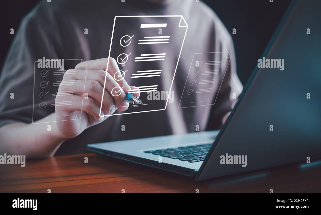 E-document management. Paperless workplace, Document management man signs an electronic document on a digital document by a virtual notebook screen. E Stock Photo