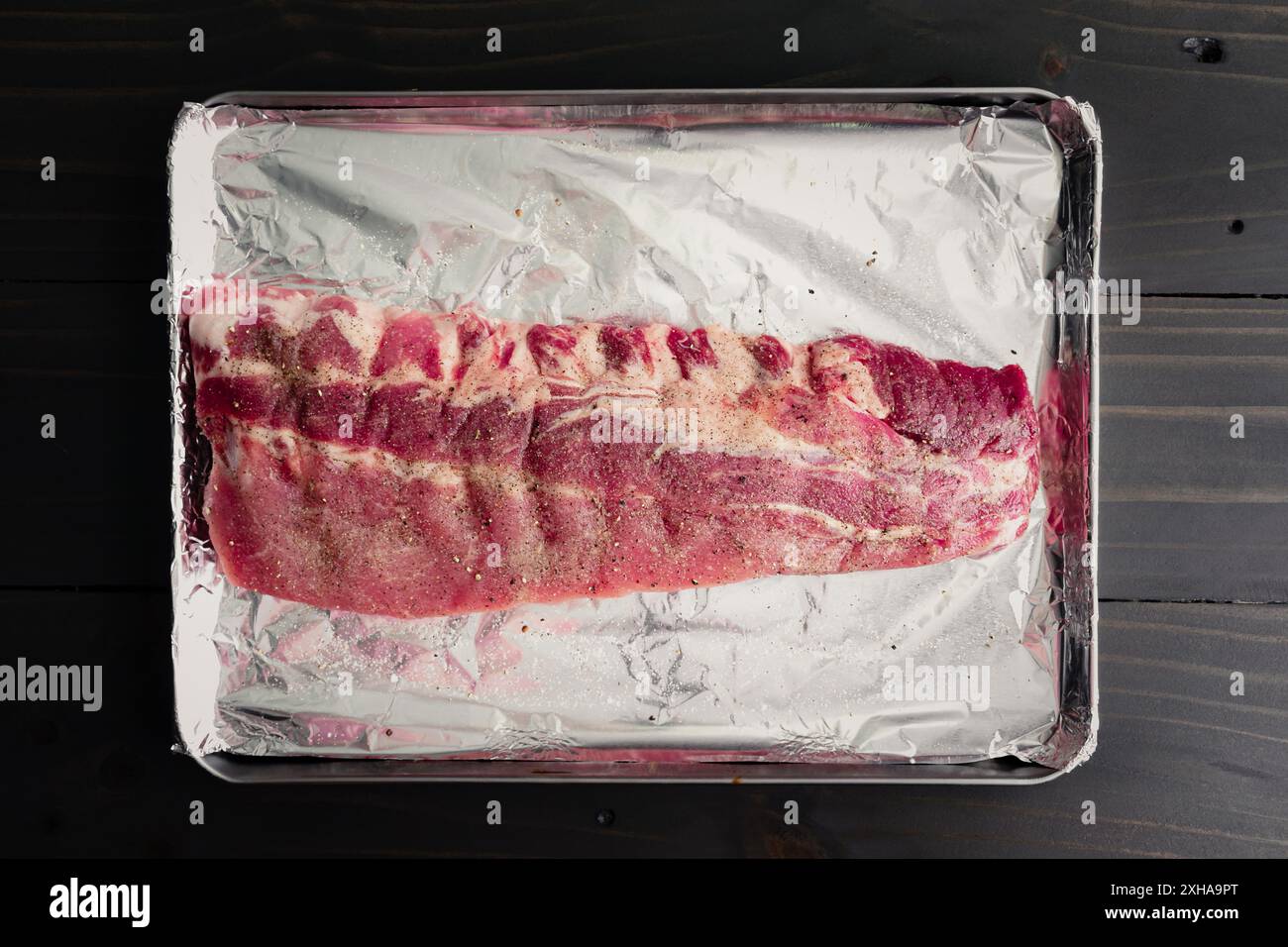 Raw Slab of Baby Back Ribs Seasoned with Salt and Pepper Uncooked