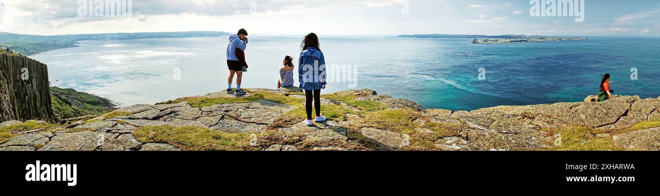 View from Fair Head cliff top to Rathlin Island on the north Antrim coast at Ballycastle, N. Ireland. Summer tourists. Panorama Stock Photo