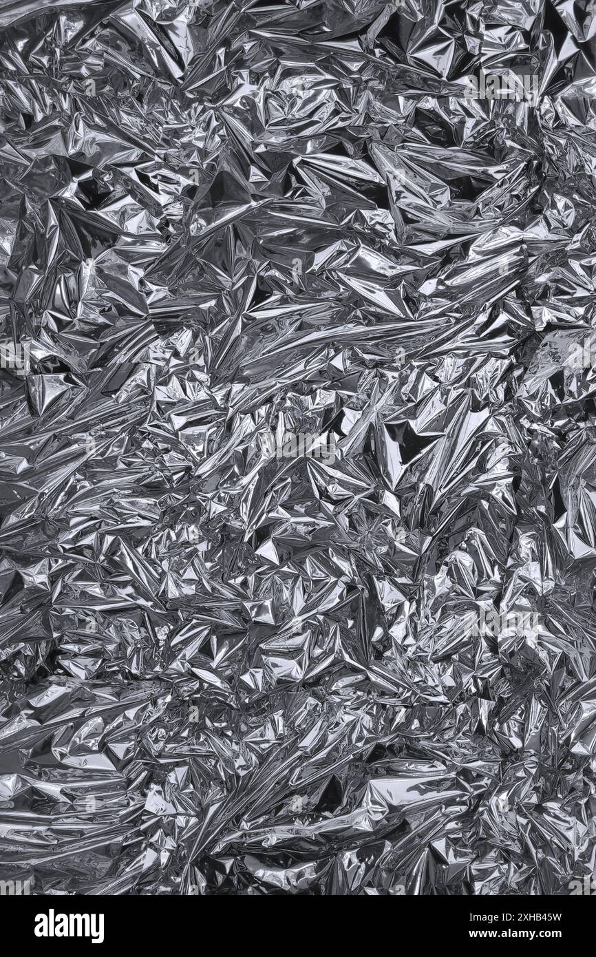 Fullframe crumpled silver foil shining texture background. Stock Photo