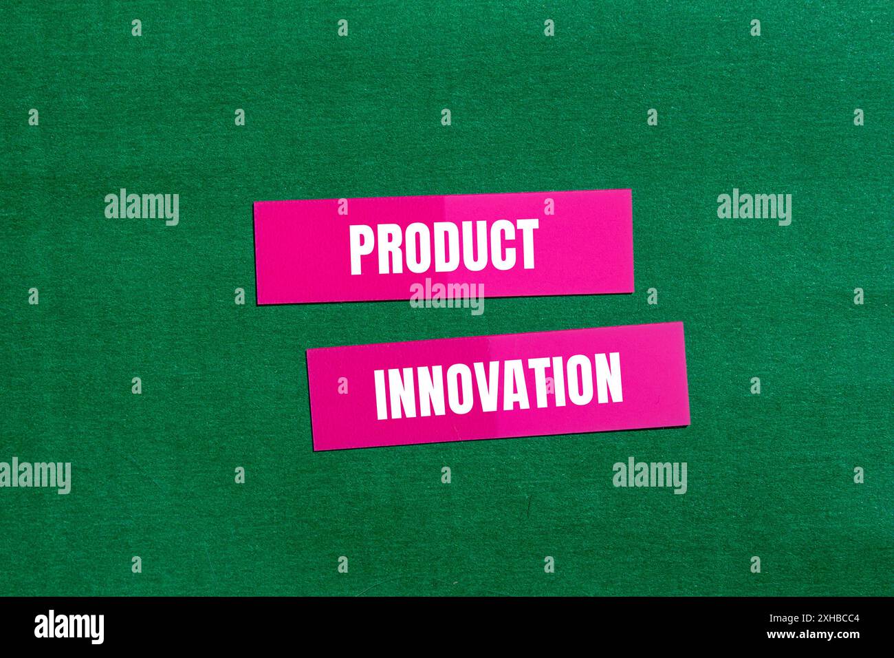 Product innovation message written on pink paper with green background ...