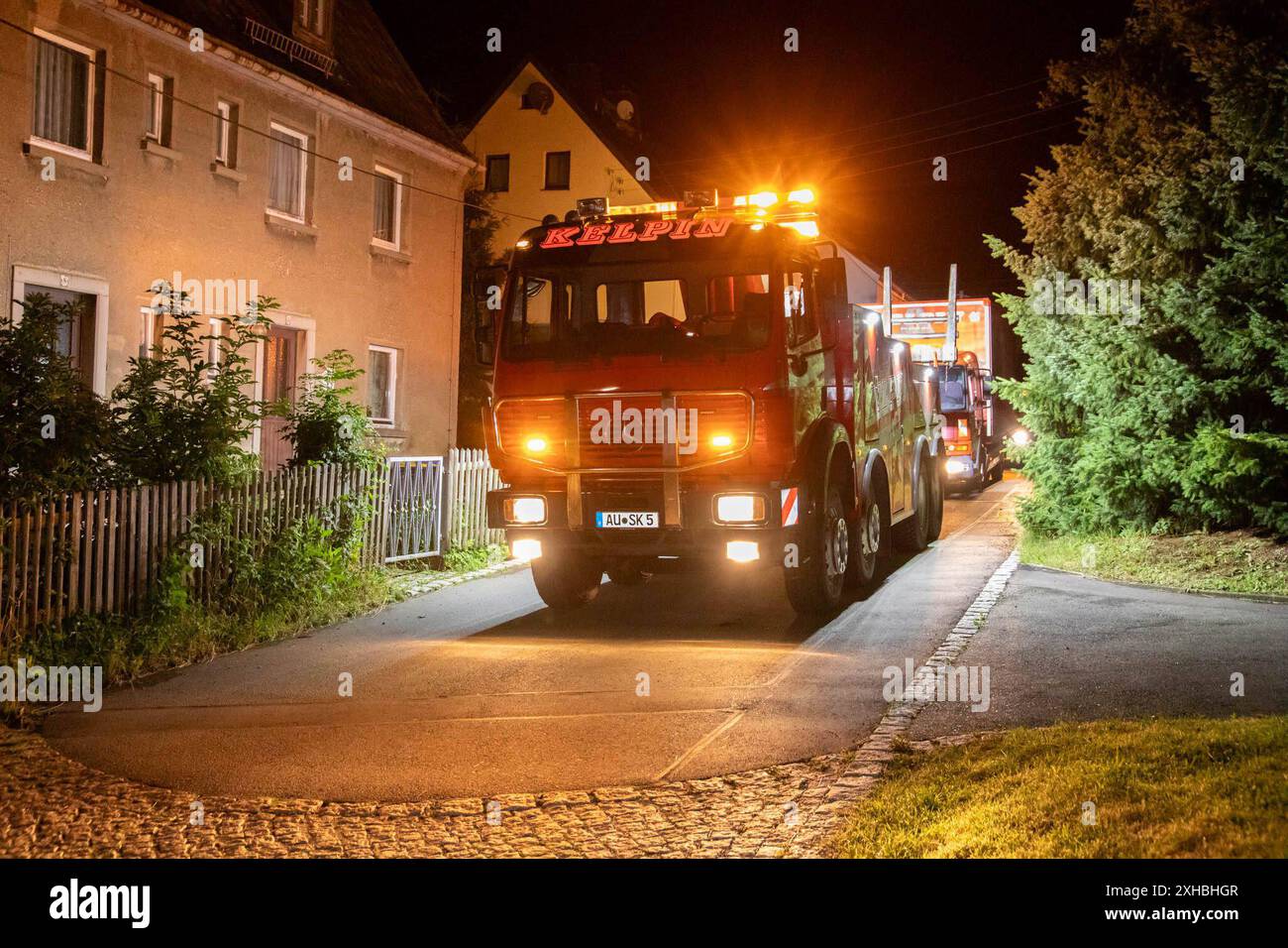 240713Bergung News ID: EN 2024-07-13 Umleitung durch Baustelle LKW verkeilt sich in Wohnsiedlung und Bergungsdienst muss Gliederzug bergen Hohndorf. Derzeit strapazieren zahlreiche Straßensperrungen und Baustellen die Nerven der Verkehrsteilnehmer. Betroffen von einer Baustellensperrung ist derzeit auch die Bundesstraße 174 in Hohndorf. Gerade LKW Fahrer müssen hier eine weitreichende, ausgeschilderte Umleitung in Kauf nehmen. Einem LKW Fahrer aus Tschechien wurde die Baustelle am Freitagabend gegen 19 Uhr zum Verhängnis. Dieser folgte nicht der ausgeschilderten Umleitungsstrecke, sondern er u Stock Photo