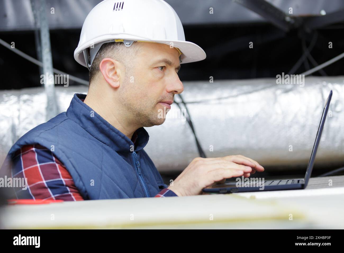 engineer working with laptop in ceiling Stock Photo