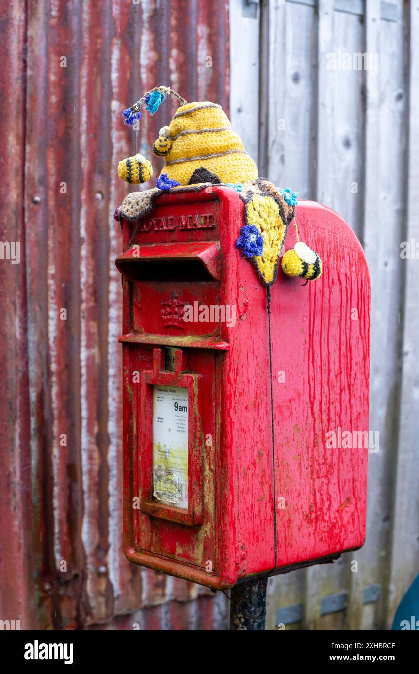 Scottish Highlands, Scotland, 2024 A Royal Mail post box with a woolen