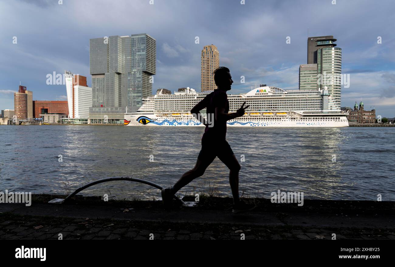 Rotterdam, skyline at the Nieuwe Maas, skyscrapers at the 'Kop van Zuid' district, cruise ship 'Aida Prima at the Cruise Terminal, jogger, Netherlands Stock Photo