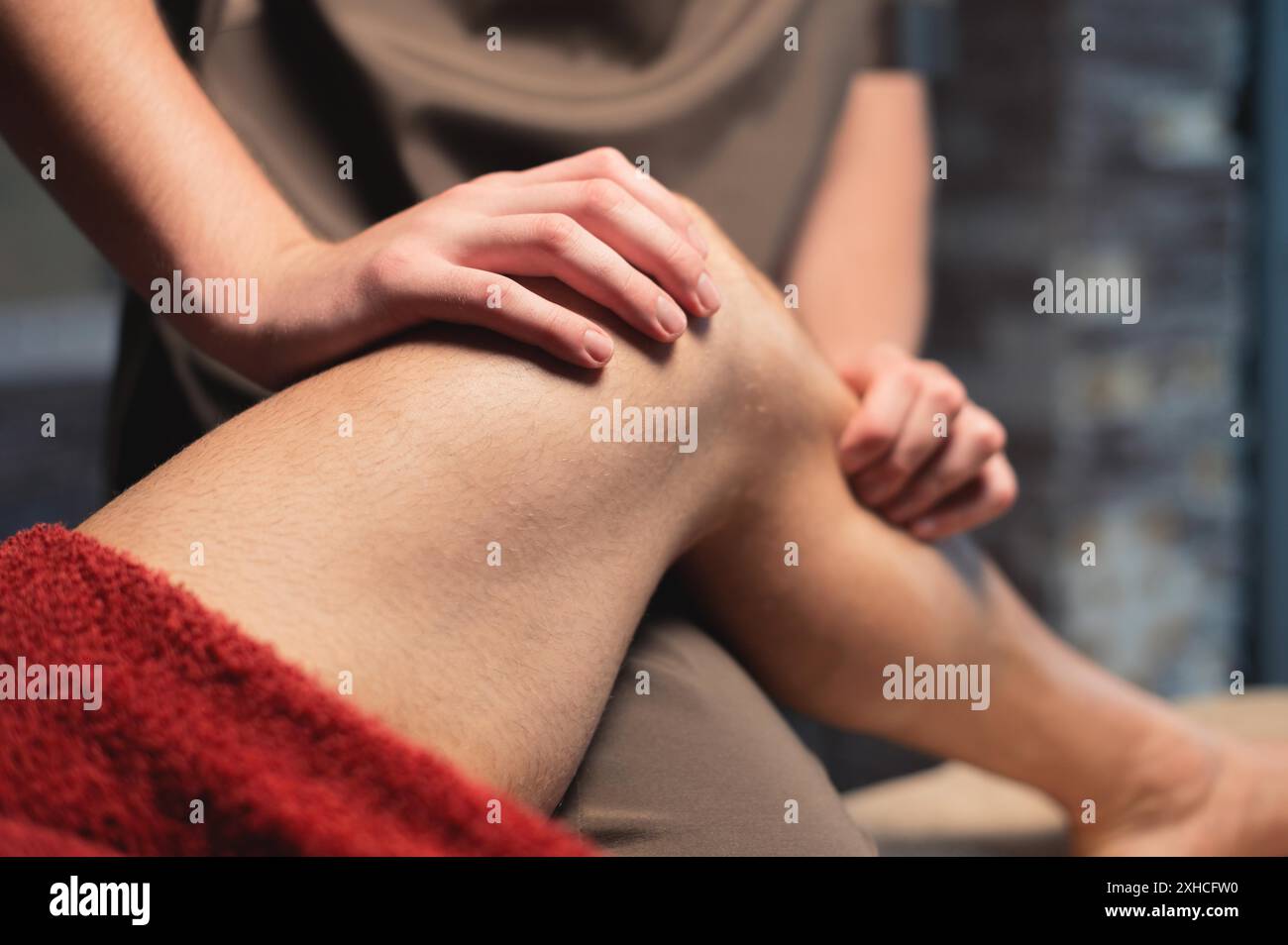 A male masseur massages the calf muscle to a male athlete in a professional massage salon. Sports massage in 4k Stock Photo