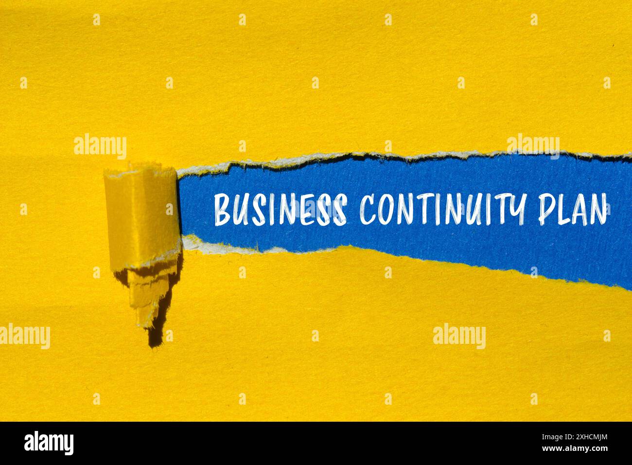 Business continuity plan message written on ripped yellow paper with ...