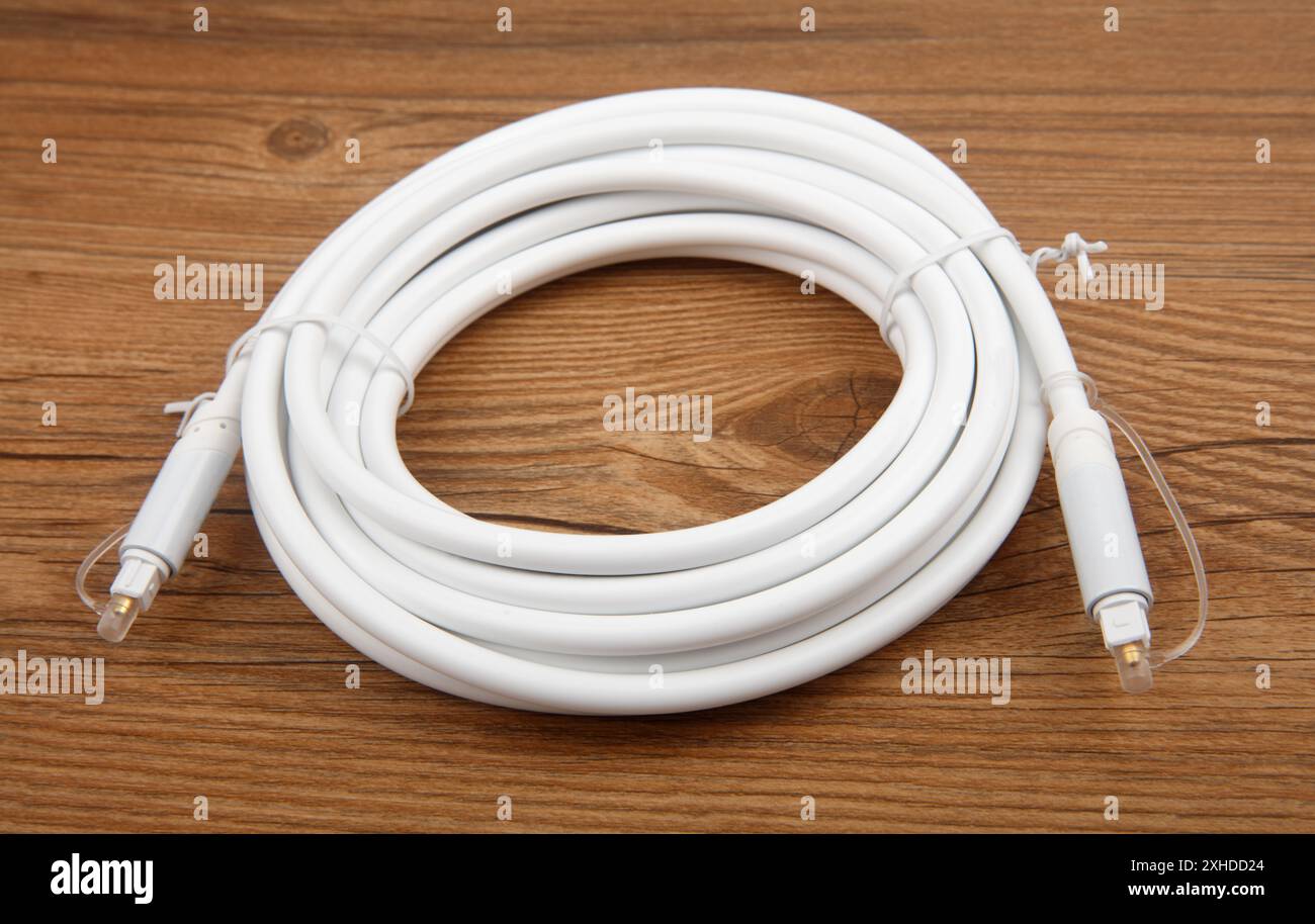 Coiled optical Audio Cable on wooden background Stock Photo