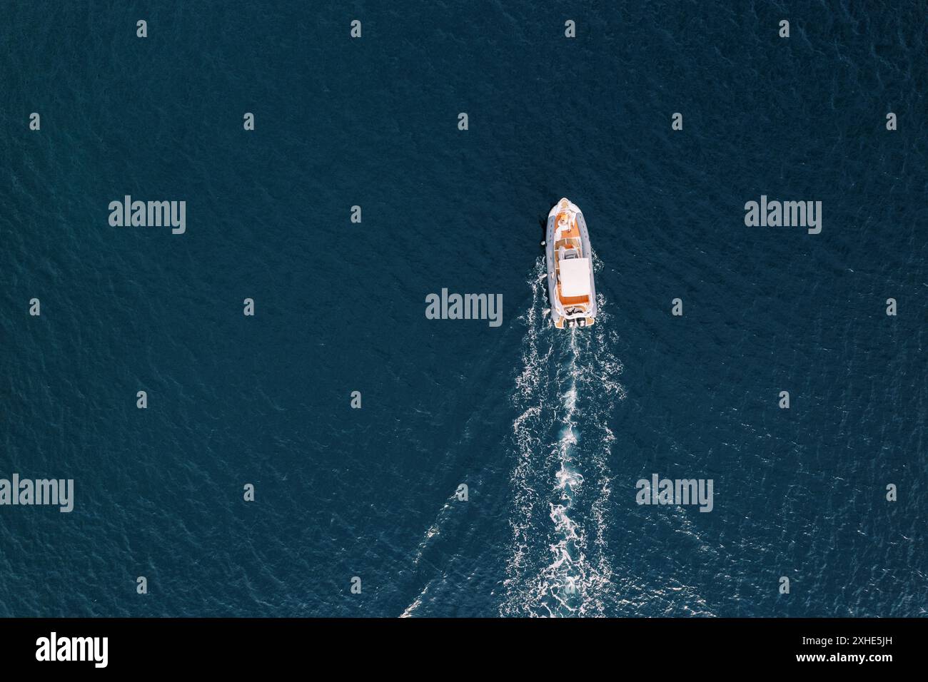 White motor yacht sails on the blue sea, leaving a foamy trail. Top ...