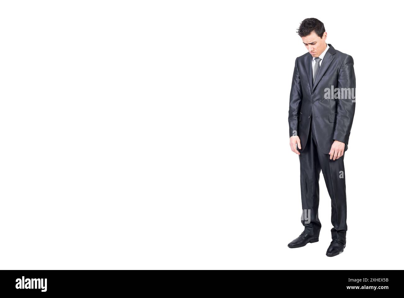 Sad young male manager looking down in white studio Stock Photo