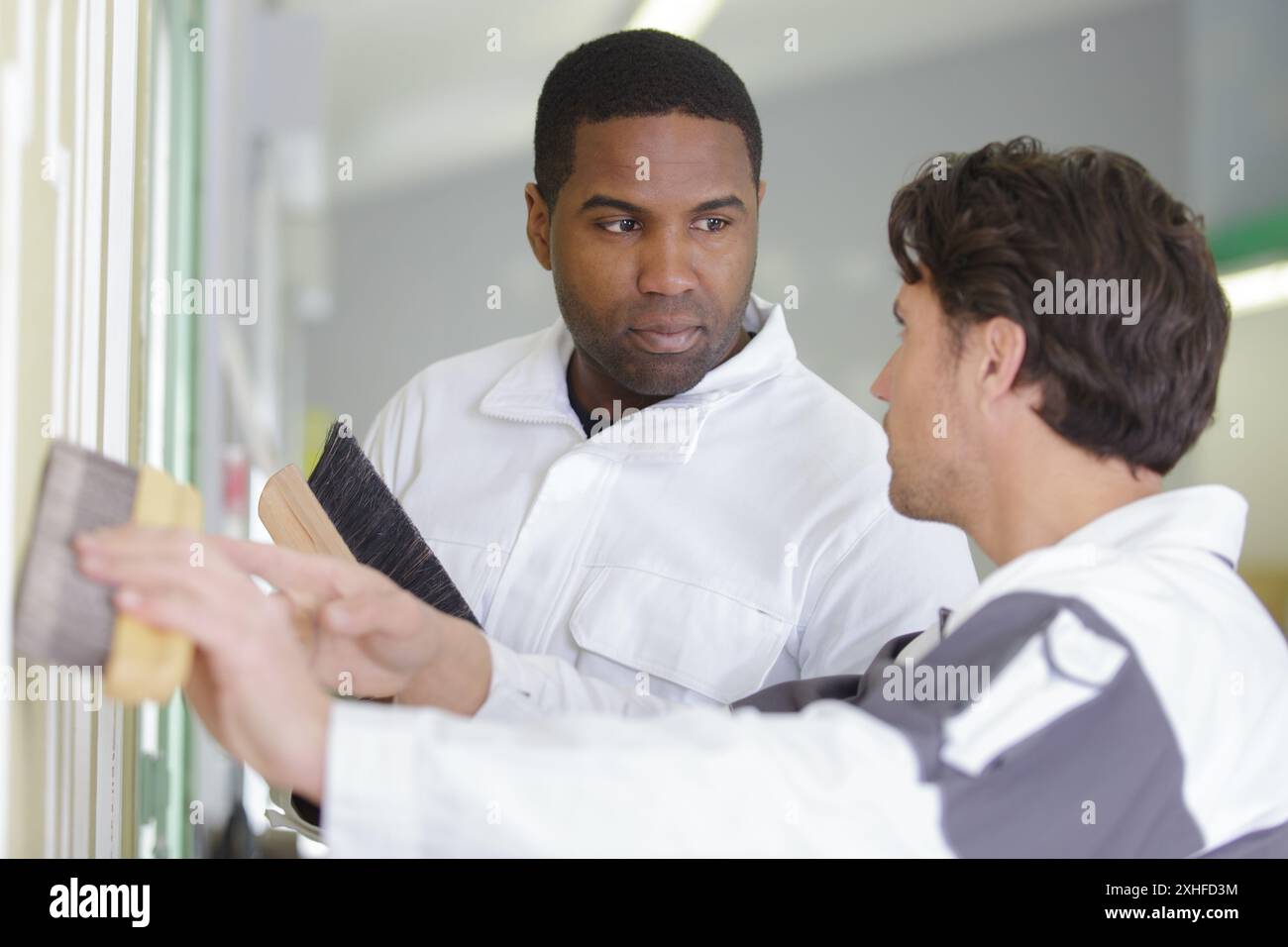 male supervisor teaching apprentice painter Stock Photo