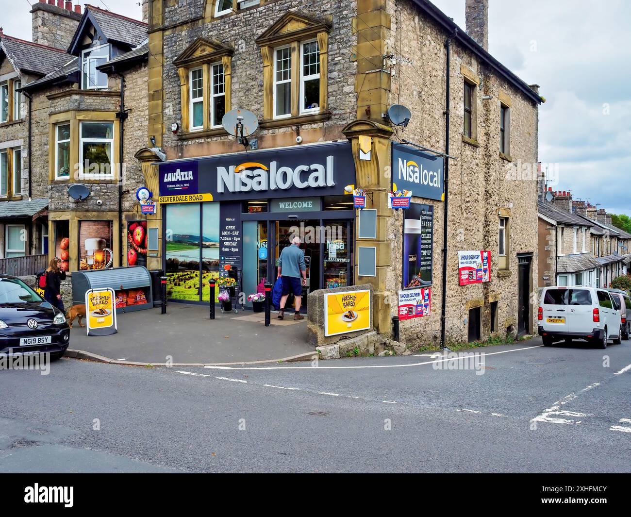 Arnside Cumbria UK. Charming neighbourhood Nisa grocery store on a street corner, with stone architecture and various products displayed outside. Stock Photo