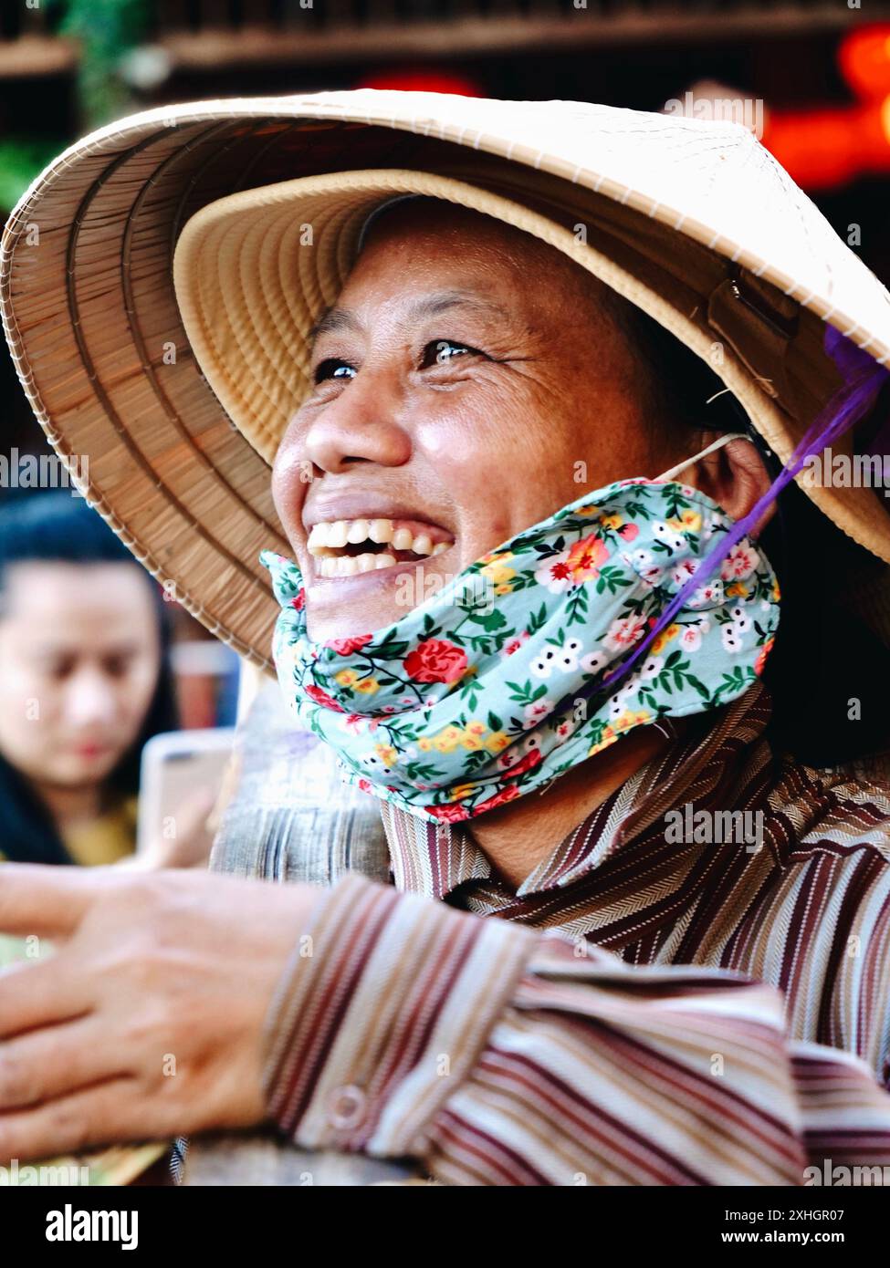 Smiling Vietnamese woman selling her products at the market. Stock Photo