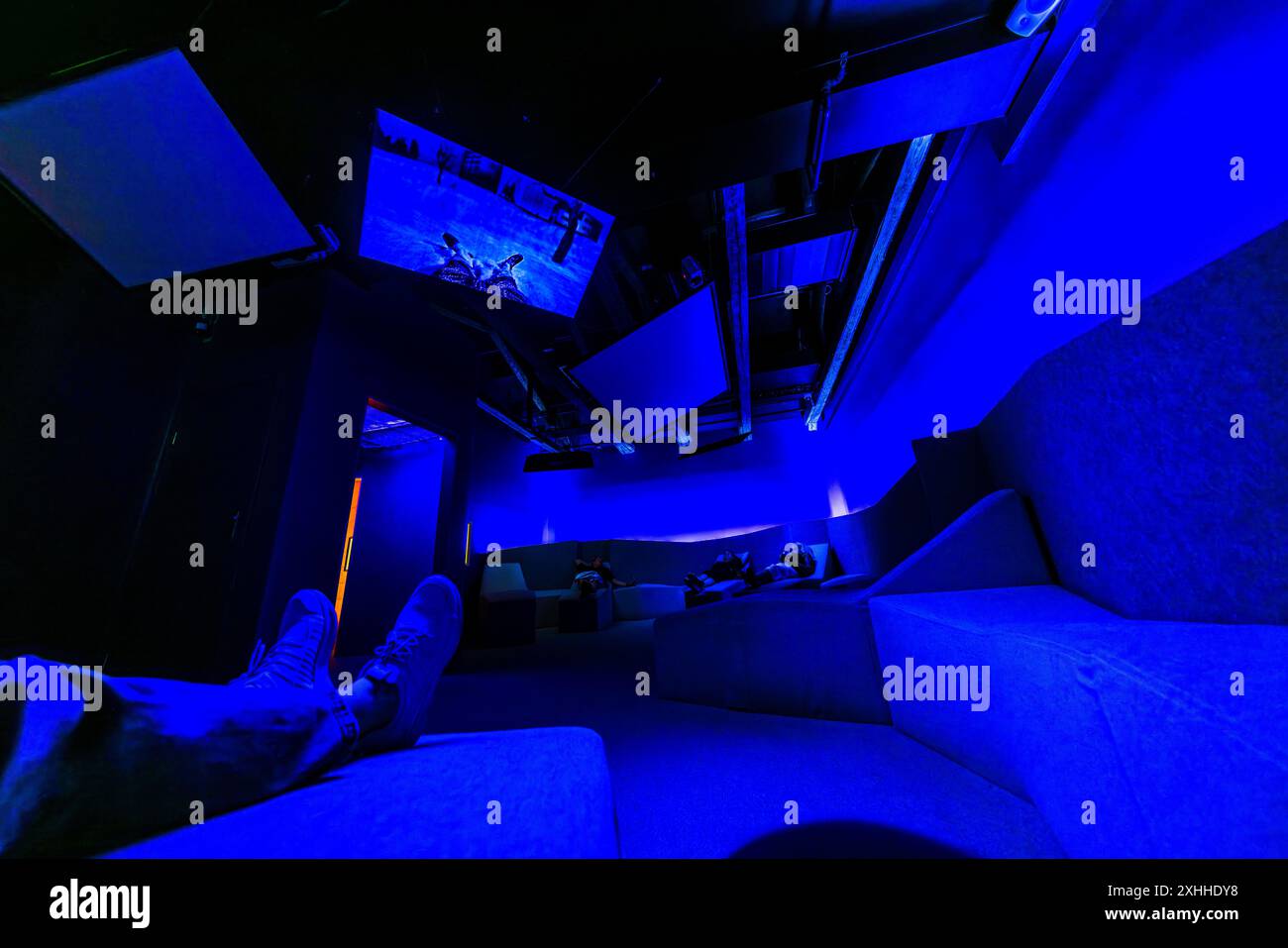 Relaxation room or sobering-up cell? The Sprit Museum in Stockholm is all about alcohol and the dangers to health. A blue-lit room installation in the Stockholm Sprit Museum. Here you can lie on sofas and watch a demonstration of the effects of delirium on monitors. Djurgårdsvägen, Stockholm, Stockholms län, Sweden Stock Photo