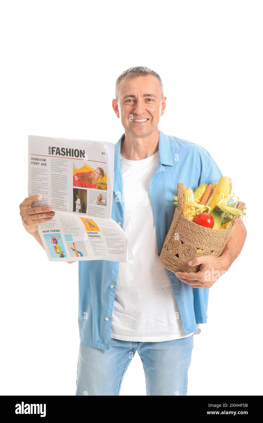 Mature male farmer with wicker basket full of ripe vegetables and ...