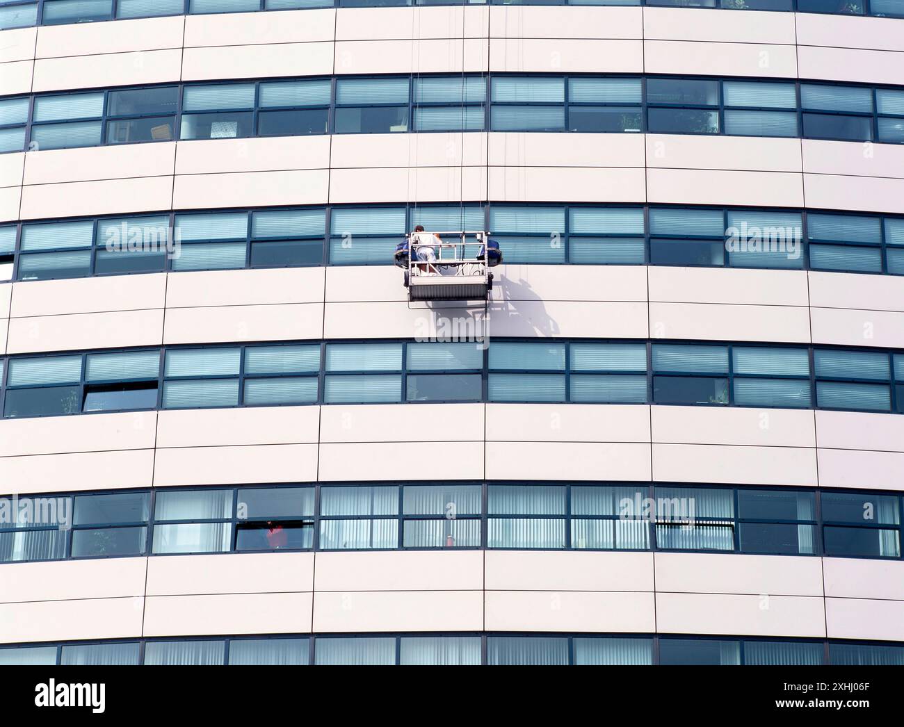 AMSTERDAM,HOLLAND-JULY 01, 2024: Window cleaning worker hanging outside ...