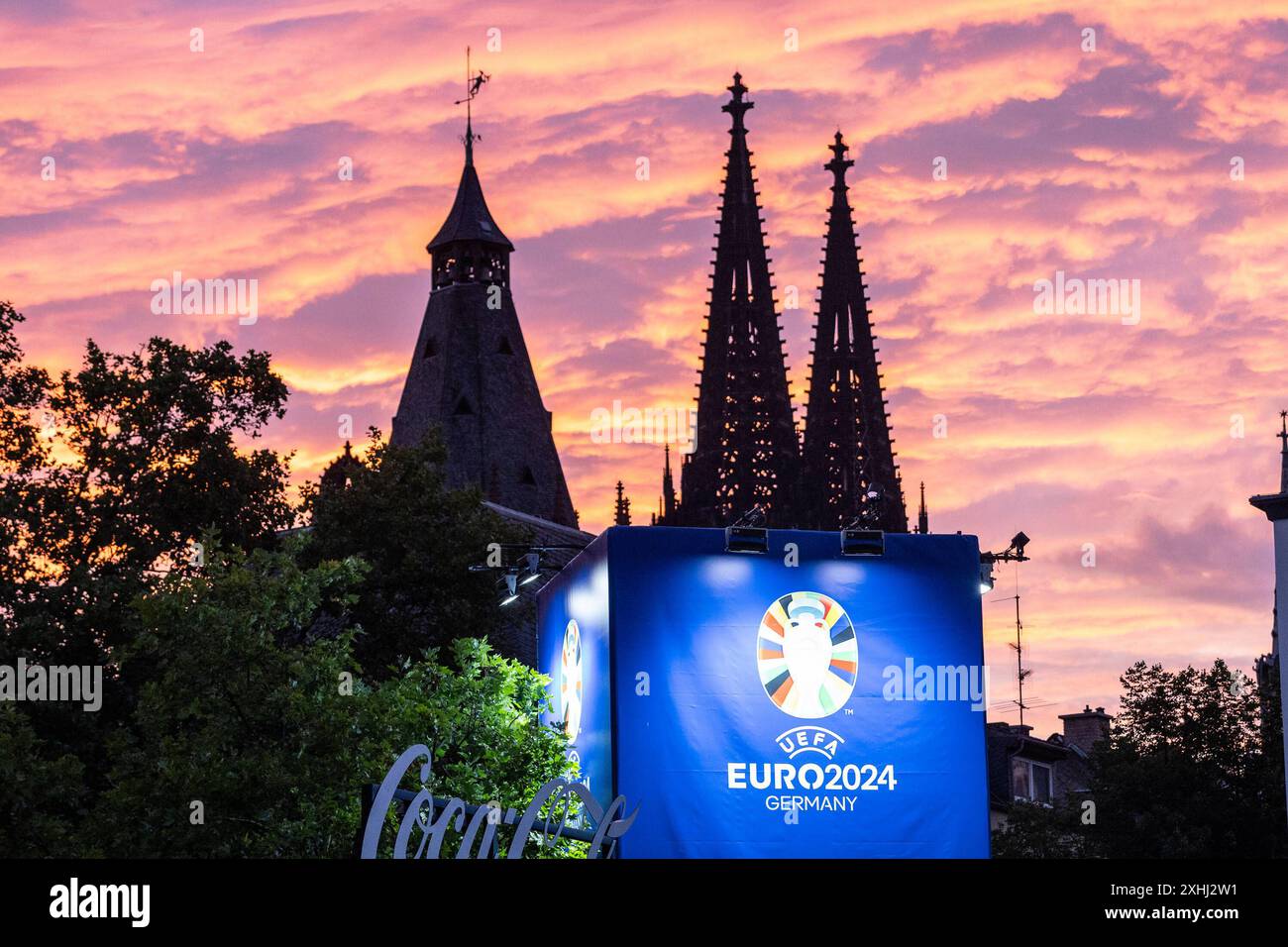 Public Viewing in Köln Fan-Zone am Heumarkt Köln 14.07.2024 Blick auf Kölner Dom, Sonnenuntergang, Logo von UEFA EURO 2024 auf dem Schild neben Eingang. Public Viewing in Köln Fan-Zone am Heumarkt Köln 14.07.2024 Köln Heumarkt NRW Deutschland *** Public Viewing in Cologne Fan Zone at Heumarkt Cologne 14 07 2024 View of Cologne Cathedral, sunset, UEFA EURO 2024 logo on the sign next to the entrance Public Viewing in Cologne Fan Zone at Heumarkt Cologne 14 07 2024 Cologne Heumarkt NRW Germany Copyright: xBEAUTIFULxSPORTS/Buriakovx Stock Photo