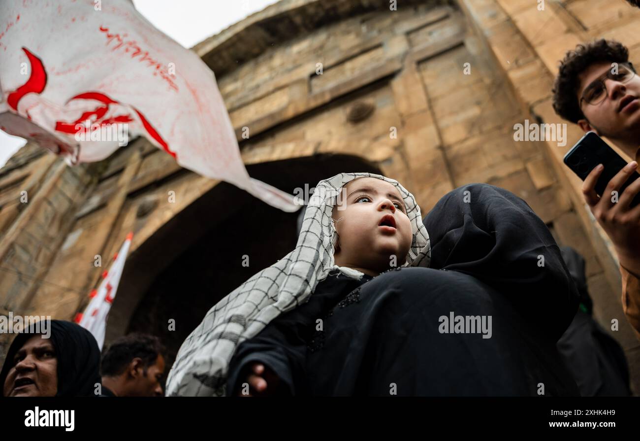 Srinagar, India. 14th July, 2024. A Kashmiri Shia Muslim baby looks on ...