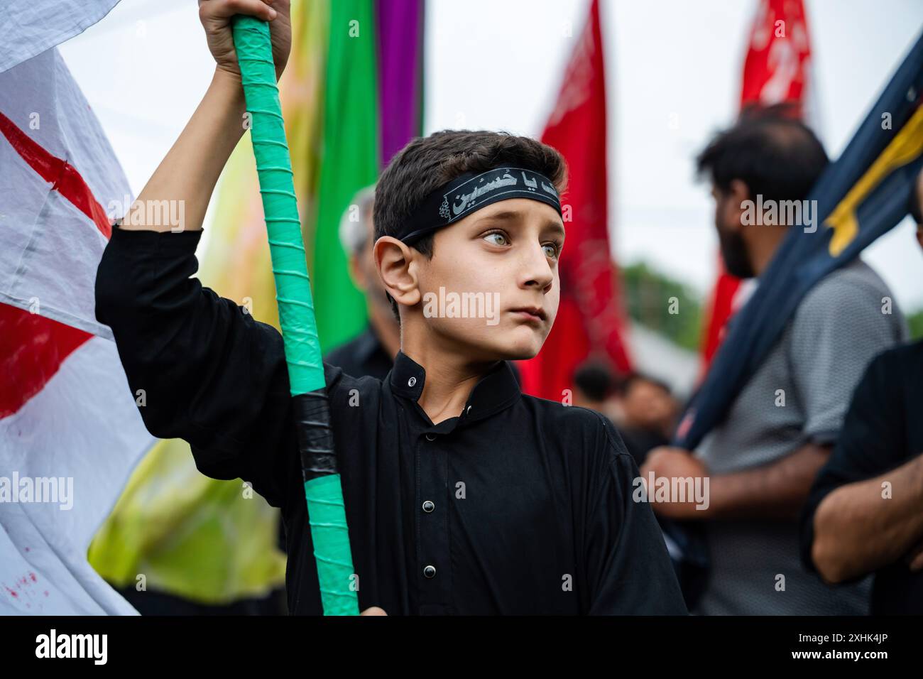 Srinagar, India. 14th July, 2024. A Kashmiri Shia Muslim boy holds a ...