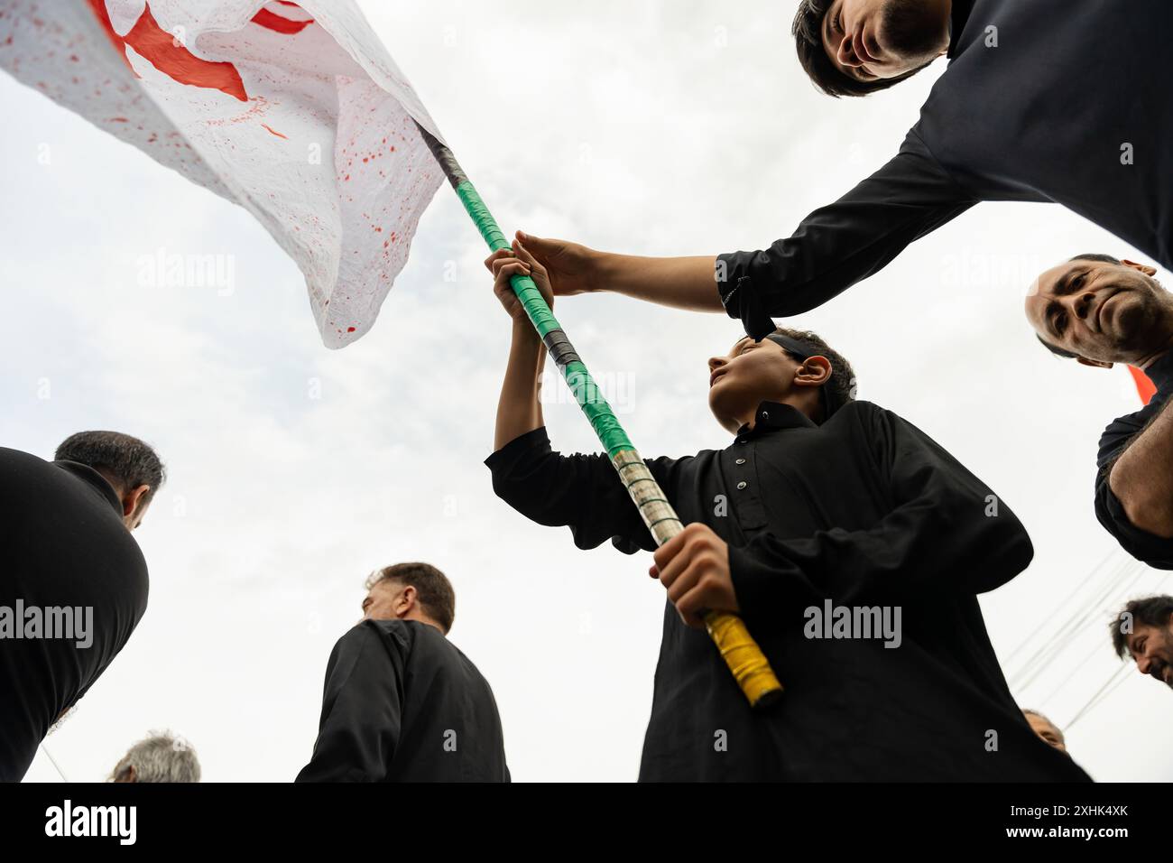 Srinagar, India. 14th July, 2024. A Kashmiri Shia Muslim boy waves a ...