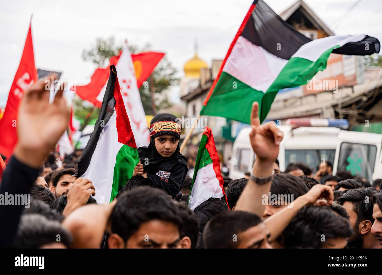 Srinagar, India. 14th July, 2024. A Kashmiri Shia girl holds a ...