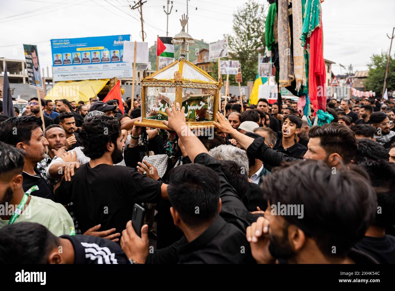 Srinagar, India. 14th July, 2024. Kashmiri Shia Muslims touch a glass ...